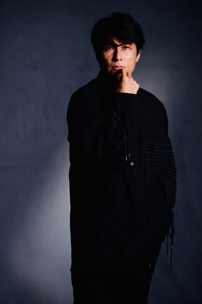 Eisuke Mochizuki in black, hand to chin